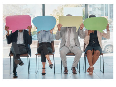 four people sitting on chairs holding cartoon speech bubbles signs