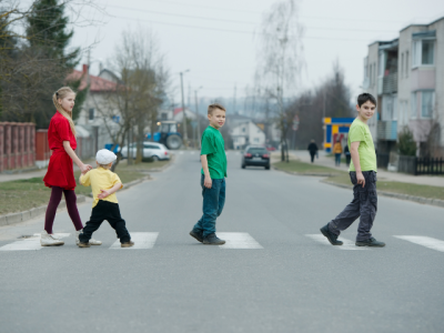 four children walking in a crosswalk