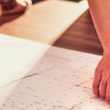 a table with a map and hands pointing to the map