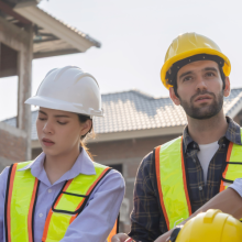 four people collaborating on a housing project at a construction site