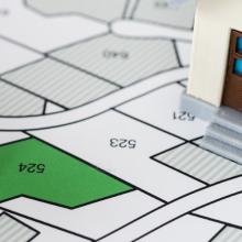 developer with project plot and small plastic house