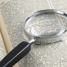 magnifying glass lying on an open dictionary