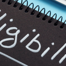pen and notebook with "eligibility" on the notebook