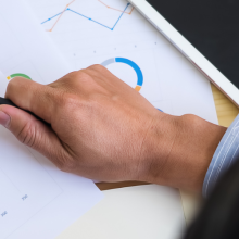 hand holding magnifying glass looking overcharts