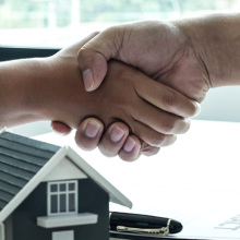 two people shaking hands after a housing deal