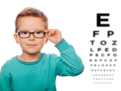 boy wearing glasses next to vision testing chart