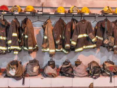 a row of firefighting gear - helmets, coats, and boots