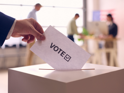 hand placing ballot into ballot box