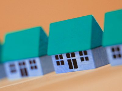 small blue and green models of three simple buildings