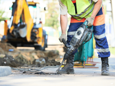 Man using jackhammer to repair road