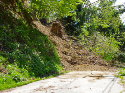 hillside landslide debris covering a paved road