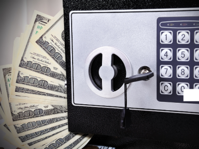 photo of hundred-dollar bills and a locked safe