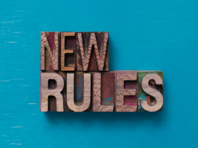 Woodcut block letters reading "New Rules" on teal background