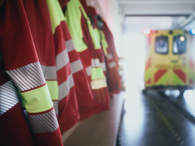 photo of row of flack jackets hanging near ambulance in fire/rescue station