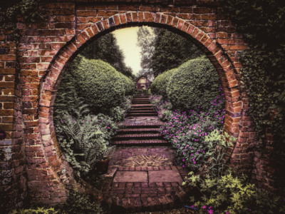 photo view of garden stairway through round brick opening