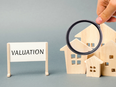 model houses, magnifying glass, and "valuation" sign
