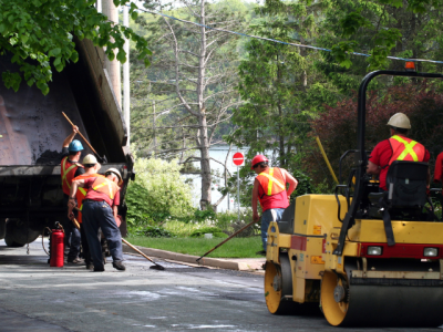 men repairing road pavement