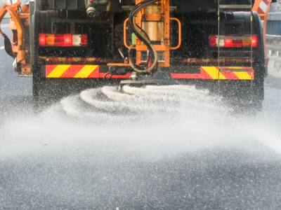 closeup photo of a highway plow dispersing road salt