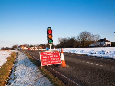 temporary workzone lighting with sign reading "wait here until green light shows"
