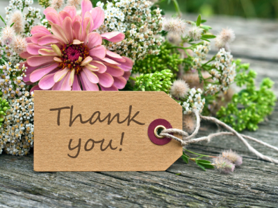 photo of Thank You handwritten on a note next to fresh flowers