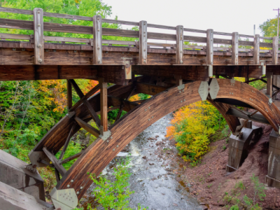 arch supported timber bridge over stream 
