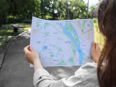 woman on a paved trail holding a map