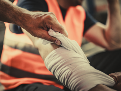 man holding head, worker holding bandaged arm, worker holding leg in pain