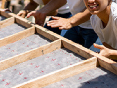 photo of four volunteers building a house
