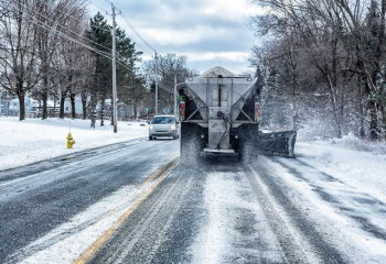 photo from car driving behind an operating snow plow
