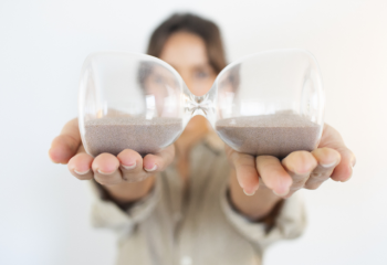 photo of an hourglass held sideways with equal amounts of sand in each side.