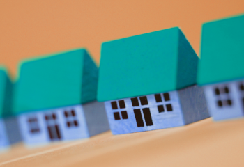 small blue and green models of three simple buildings