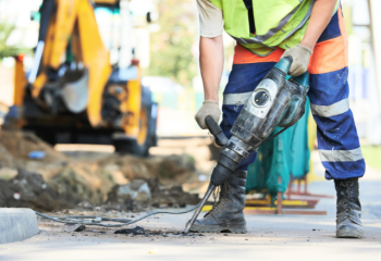 Man using jackhammer to repair road