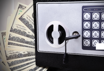 photo of hundred-dollar bills and a locked safe