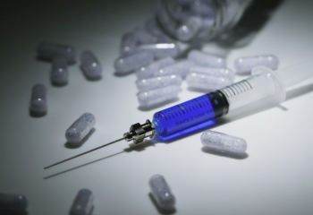 photo of pills and a hypodermic needle