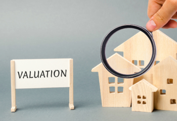 model houses, magnifying glass, and "valuation" sign