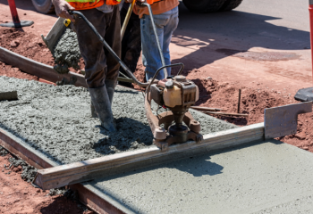 person constructing a concrete sidewalk