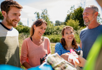 four smiling people in the outdoors