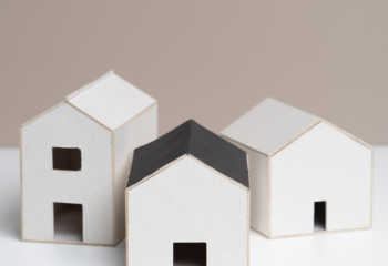 small white models of three simple buildings