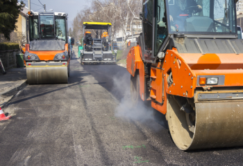 photo of three vehicles being used to re-pave a local road