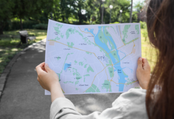 woman on a paved trail holding a map