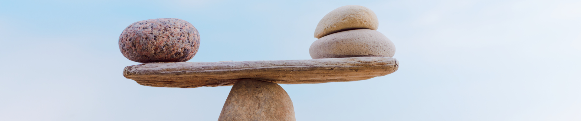 a single rock and two rocks balanced on a central rock point