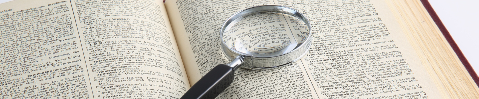 magnifying glass lying on an open dictionary