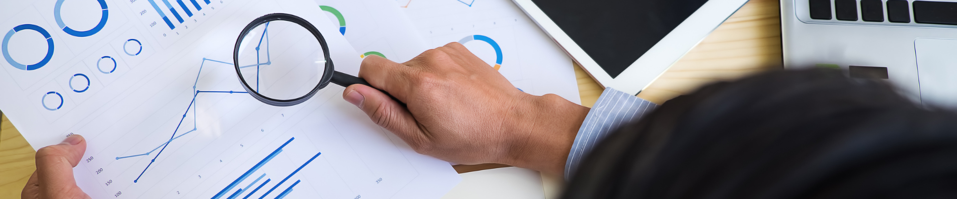 hand holding magnifying glass looking overcharts