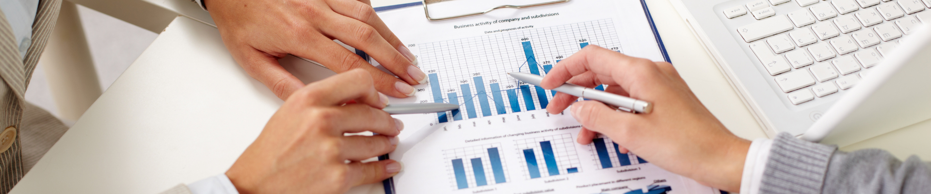 hands holding pens and pointing at business documents