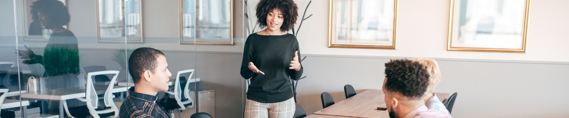 woman presenting in conference room to three people