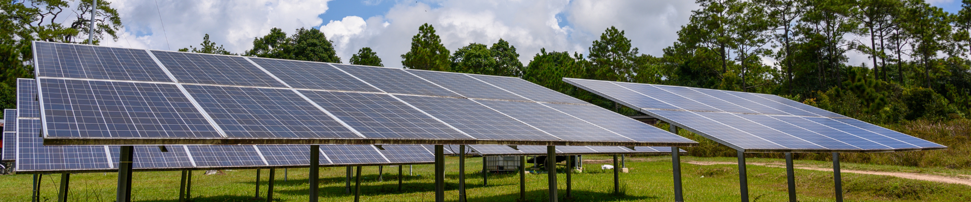 several rows of solar panels in a field
