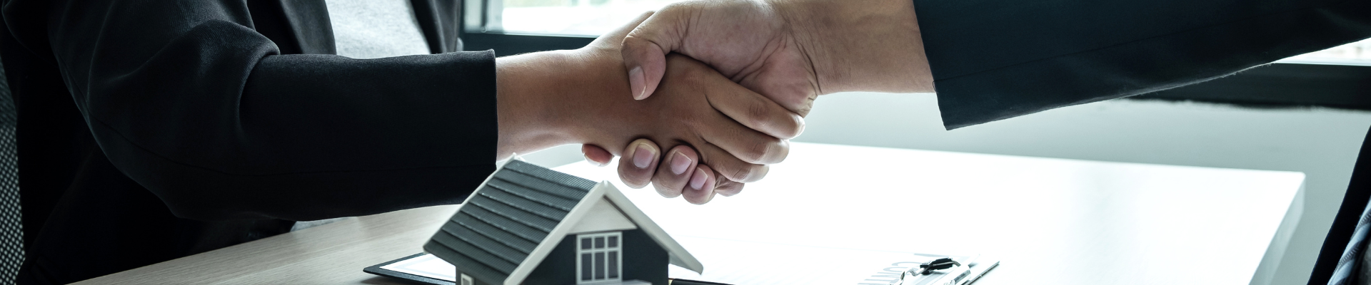 two people shaking hands after a housing deal
