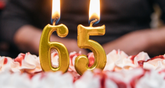 birthday cake with large "6" and "5" candles on it.