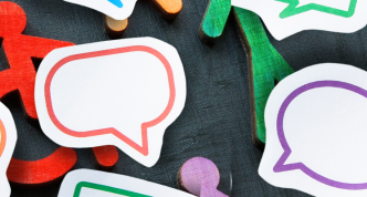 different colored wooden people blocks and speech bubbles