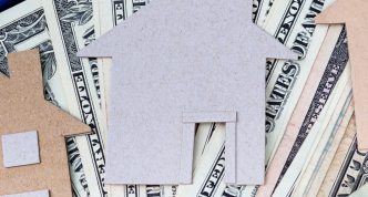 dollar bills overlain by cutouts of house shapes